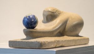Limestone sculpture called "The Gift" carved in Indiana limestone in 2016 and including a Lapis Lazuli sphere. Side right view.