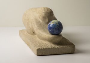 Limestone sculpture called "The Gift" carved in Indiana limestone in 2016 and including a Lapis Lazuli sphere. Frontal left view.