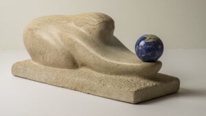 Limestone sculpture called "The Gift" carved in Indiana limestone in 2016 and including a Lapis Lazuli sphere. Side left view.